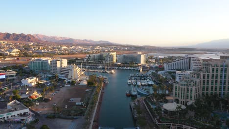 Aerial-view-of-Eilat-city,-resorts,-hotels,-yachts-and-marina-during-golden-hour