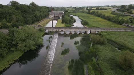 Drone-shot-of-a-river-with-an-old-stone-bridge-crossing-it