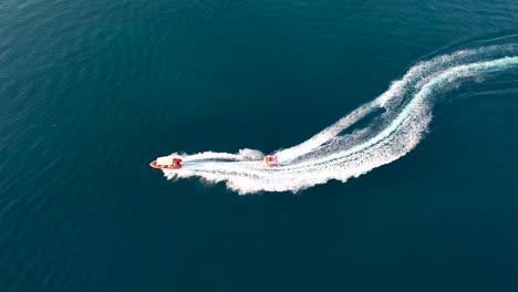 Top-down-view-of-speed-boat-towing-a-ski