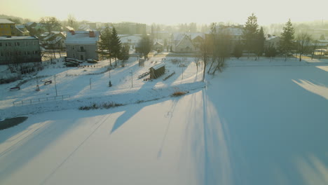 Auto-überquert-Die-Straße-In-Der-Kalten-Und-Schneebedeckten-Polnischen-Stadt-Bei-Gelbem-Sonnenaufgang