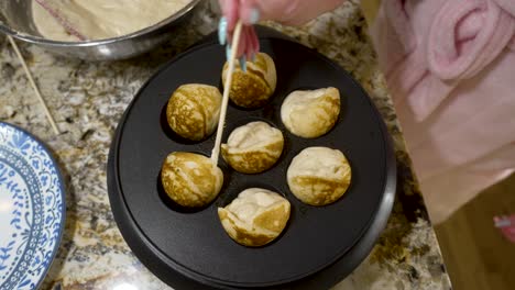 Turning-aebleskivers-in-a-hot-pan-so-they-cook-evenly---overhead-view-AEBLESKIVER-SERIES