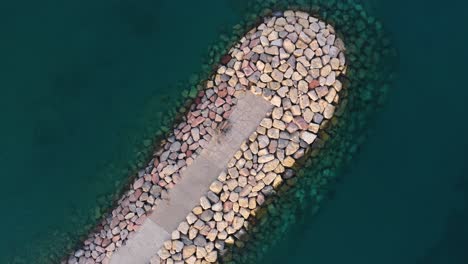 Aerial-footage-of-a-breakwater-made-out-of-rocks-at-the-very-clear-waters-of-the-Red-Sea