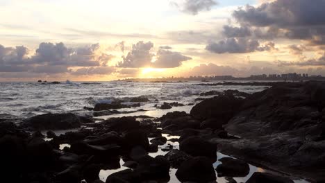 beautiful-sea-waves-crash-on-rocks-of-beach-coast-at-sunset,-zooming-in