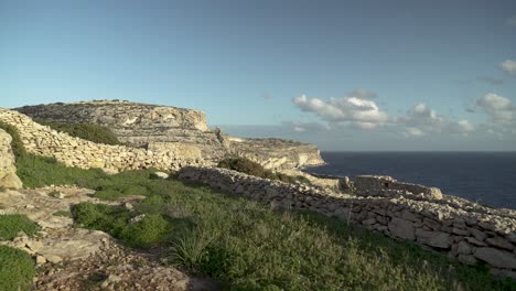 Caminando-Sobre-La-Tierra-De-Los-Granjeros-En-La-Parte-Superior-De-La-Gruta-Azul-En-Una-Hora-Dorada-Por-La-Noche-En-Malta