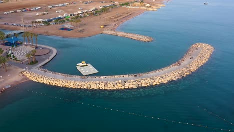 Aerial-view-of-a-breakwater-at-Eilats-city-broadwalk,-South-Israel
