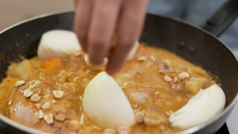 Cocinar-Pollo-Al-Curry-Massaman-Del-Sur-De-Tailandia-Con-Cebolla,-Zanahoria-Y-Cacahuetes