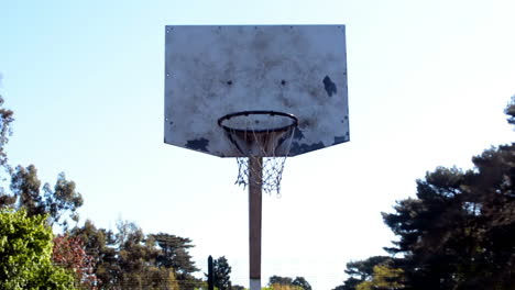 Throwing-a-ball-into-a-basketball-basket,-still-shot-of-a-basketball-hoop-in-an-outdoor-public-court