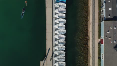 Top-down-aerial-view-of-small-sailboats-tied-up-to-a-dock