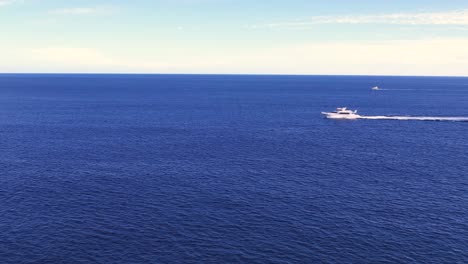 Drohne-Fliegt-In-Richtung-Schnellboot,-Das-über-Die-Leuchtend-Blaue-Meeresoberfläche-Segelt,-Pazifischer-Ozean