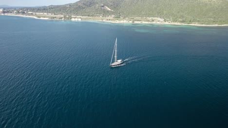 Aerial-orbit-over-the-small-yacht-sailing-on-the-calm-surface-of-the-turquoise-Mediterranean-waters