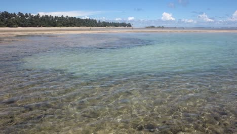 Static-view-of-shallow-clean-sea-water-during-low-tide-with-the-view-of-sea-bed-in-Morro-de-Sao-Paulo,-village-in-Tinhare-island-in-Bahia,-Brazil