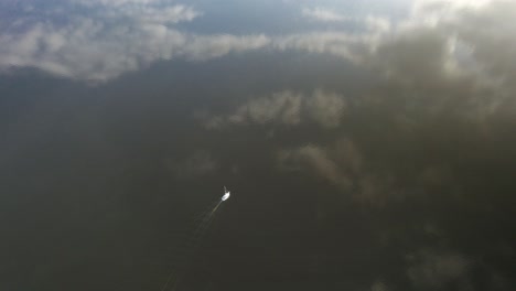 Aerial-high-altitude-following-shot-over-a-lonely-yacht-sailing-on-the-calm-dark-waters-in-northern-Europe