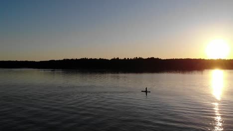 Paddleboarding-in-the-sunset-at-a-Swedish-lake-during-a-warm-summer-night
