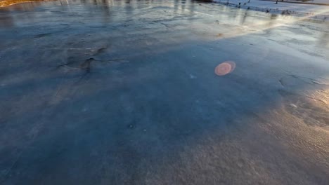 Schnelle-Drohne,-Die-Während-Des-Sonnenuntergangs-über-Einem-Zugefrorenen-Teich-In-Michigan-Fliegt