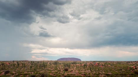 Gewitterwolken-Und-Regen,-Die-Während-Des-Sonnenuntergangs-über-Den-Uluru-Ziehen