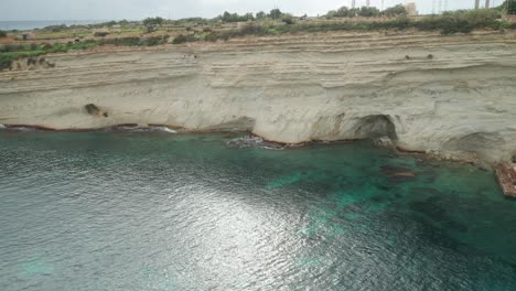 AERIAL:-Limestone-Wall-of-Ta-Kalanka-Sea-Cave-Bay-Washed-with-Turquoise-Color-Sea