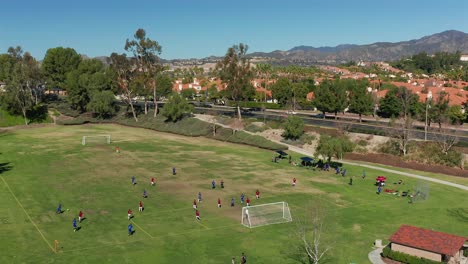 Aerial-view-of-a-soccer-game-between-Red-and-Blue-at-Melinda-Park-in-Mission-Viejo,-California