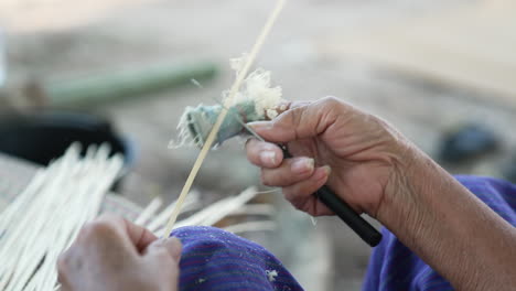 Slow-Motion-Scraping-Off-Bamboo-Sticks-with-a-Knife,-Skillful-Bamboo-Weaving,-Close-Up