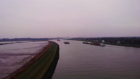 Aerial-Rising-From-Crezeepolder-On-Overcast-Day-With-Ships-Navigating-River-Noord