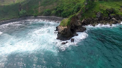 Waves-breaking-on-rocky-cliffs-at-Menganti-beach,-Kebumen-in-Indonesia