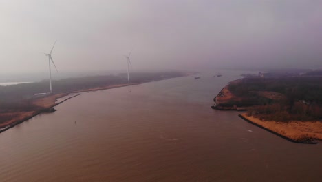 Aerial-Flying-Over-Oude-Maas-With-Wind-Turbines-Seen-Through-Dense-Fog-In-Distance-In-Barendrecht