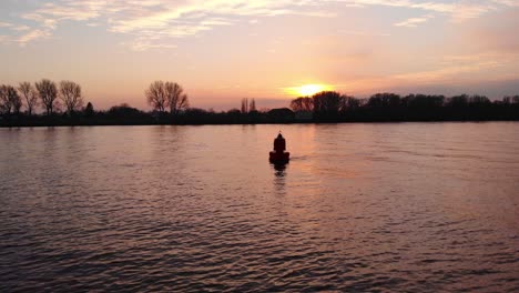 Luftschattenbild-Der-Schwimmenden-Boje-Im-Fluss-Während-Des-Orangefarbenen-Sonnenunterganghimmels