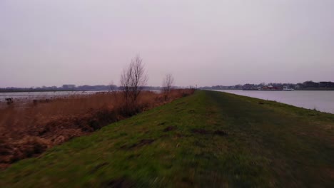 Aerial-POV-Along-Grass-Verge-Beside-Crezeepolder-Nature-Reserve-At-Ridderkerk-In-Netherlands