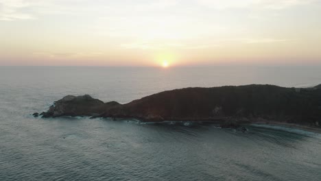 Aerial-view-of-beautiful-sunset-over-the-horizon-on-the-Pacific-coastline-along-the-hilly-terrain-in-Mazunte-in-Southern-Mexico