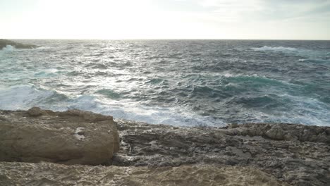 Limestone-Beach-with-Waves-Crashing-on-Shore-of-Gozo-Island-During-Windy-Day-in-December
