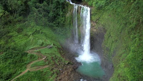 Aerial-rising-on-Eco-Chontales-waterfall-and-natural-turquoise-pond-surrounded-by-dense-green-rain-forest,-Costa-Rica