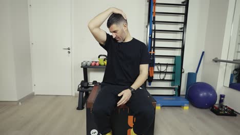 Wide-shot-of-a-man-stretching-his-neck-muscles-before-a-workout