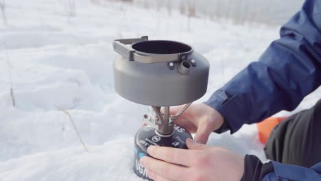 Camper-Assembling-Camping-Teapot-Kettle-On-Portable-Stove-At-Winter