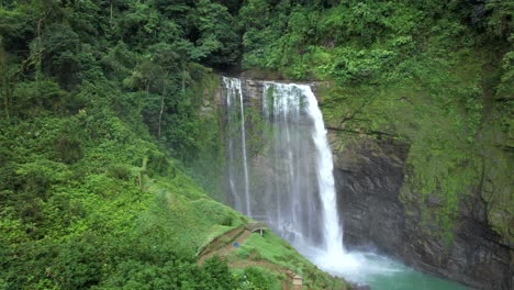 Aerial-truck-right-of-Eco-Chontales-waterfall-streaming-into-turquoise-natural-pond-surrounded-by-green-jungle,-Costa-Rica