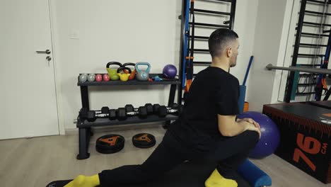 A-man-stretches-his-legs-as-he-warms-up-before-a-work-out