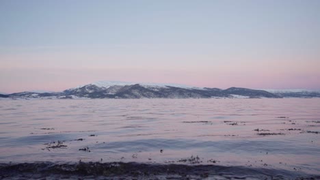 Dramatischer-Sonnenuntergang-über-Dem-Trondheimfjord-In-Vanvikan,-Indre-Fosen,-Trondelag,-Norwegen-Mit-Schneebedeckten-Bergen-Im-Hintergrund