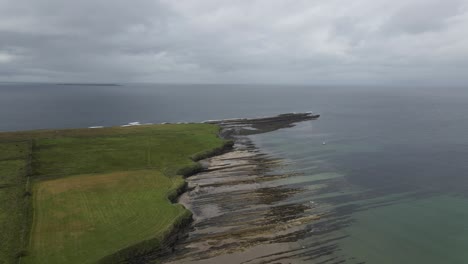 Drone-shot-of-a-small-headland-with-small-cliffs-in-Ireland