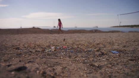 Mikroplastik-Am-Strand,-Im-Hintergrund-Eine-Frau-Und-Ein-Hund