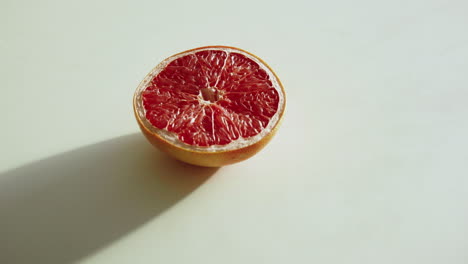 Push-in-sliced-grapefruit-on-a-white-kitchen-table