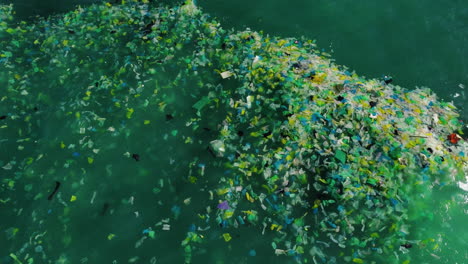 Ocean-water-full-of-rubbish-and-plastics,-aerial-top-down-shot