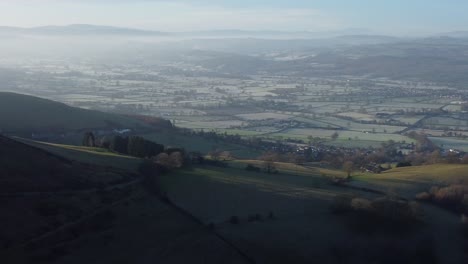 Distant-misty-layers-of-panoramic-rural-mountain-valley-North-Wales-countryside-at-sunrise-aerial-view-right-pan
