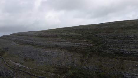 Drone-shot-of-a-mountain-in-the-Burren,-Ireland-covered-in-rocks