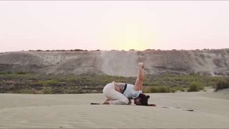 Junger-Yogalehrer-Auf-Einem-Sandhügel,-Der-Bei-Sonnenaufgang-Eine-Morgendliche-Routine-Durchführt