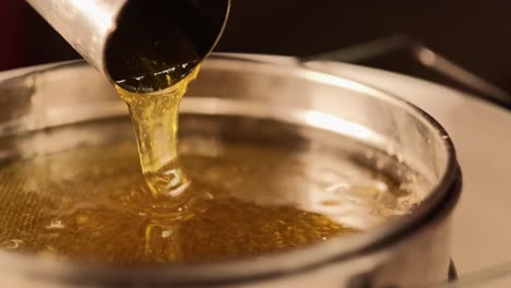 Closeup-Shot-Of-Natural-Honey-Liquid-During-Liquid-Extracting-Process