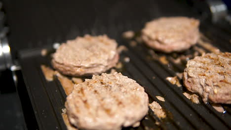 Close-up-slider-shot-of-Meat-Burger-Cutlet-On-Hot-Grill-Pan