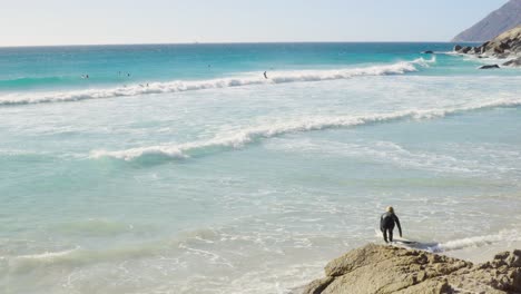 Der-Surfer-Macht-Sich-Bereit,-Am-Strand-Von-Noordhoek-In-Südafrika-In-Die-Wellen-Zu-Springen