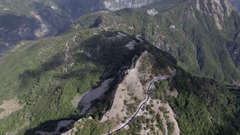 drone-video-of-"A-bird's-eye-view",-advancing-on-the-highest-of-the-sh21-the-Theth-mountain-pass-in-albania,-Gjecaj