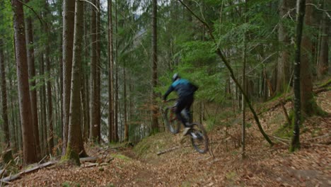 A-mountain-biker-does-a-big-jump-at-high-speed-in-a-forest