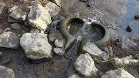 River-flowing-through-primitive-weathered-eroded-smooth-stone-worn-basin-looking-down