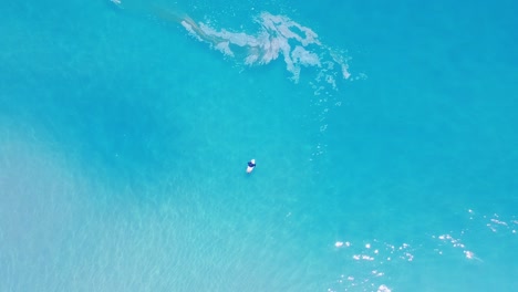 Surfer-waiting-on-waves-in-aqua-coloured-ocean