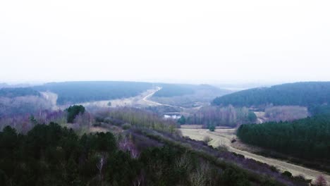 A-lake-in-a-country-park-in-the-morning-fog-shot-on-a-DJI-drone-moving-forward-English-countryside
